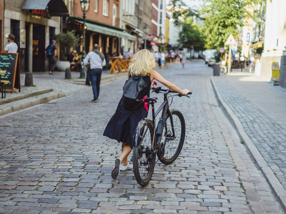 Radfahrerin in der Altstadt – Fahrradabstellplätze für Städte und Gemeinden