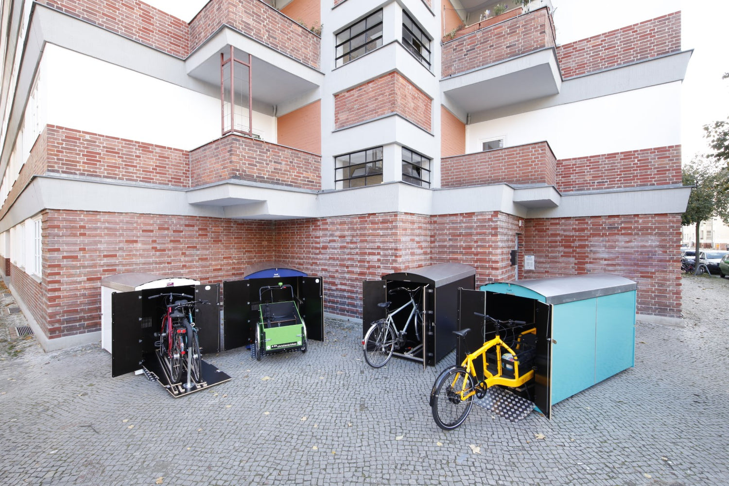Diebstahlsichere Aufbewahrungsboxen für Fahrräder und Kinderwagen vor Wohnhaus