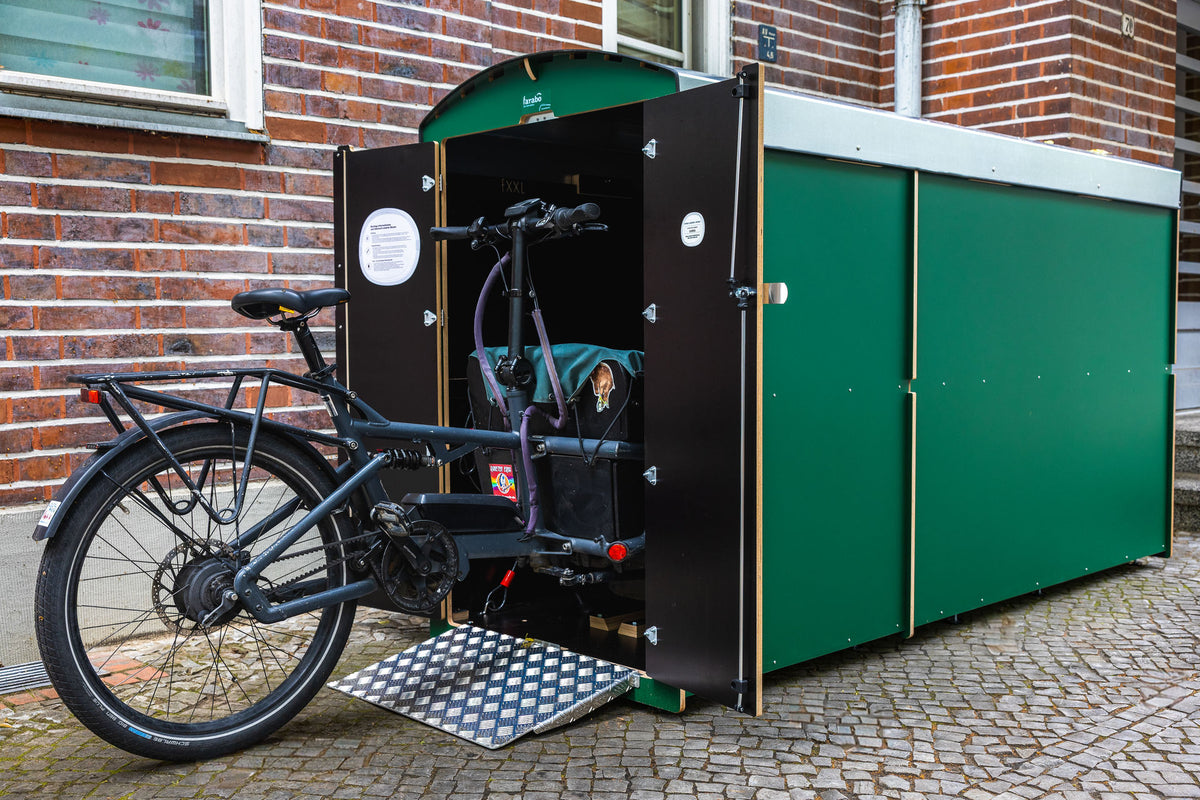 Grüne farabo Doppelbox, offen, mit Lastenrad vor Backsteinfassade