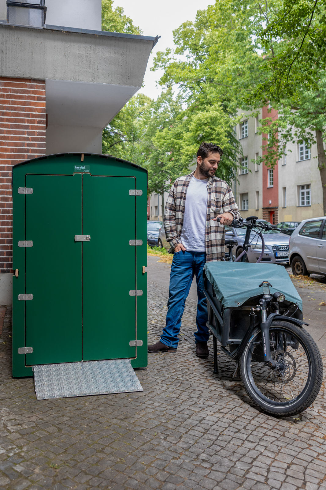 Grüne farabo Box mit Lastenrad und Mann, Hochformat