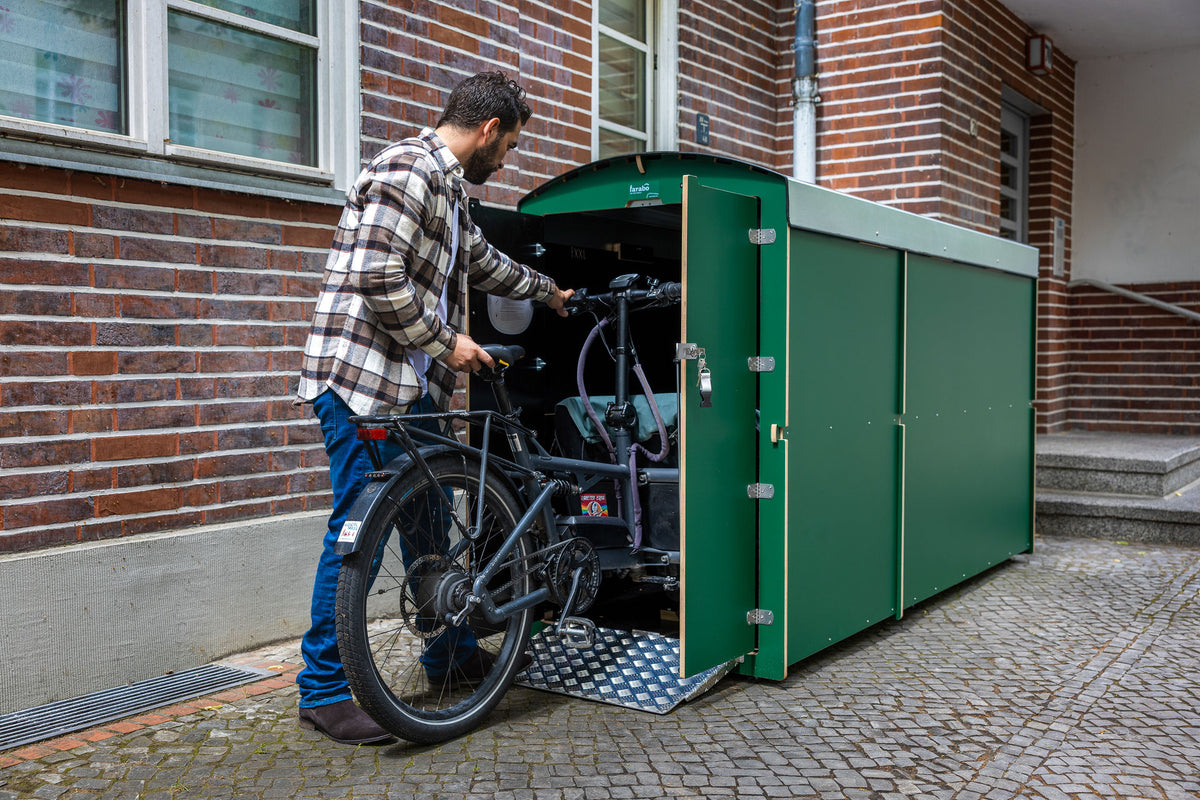 Mann mit Lastenrad an grüner farabo Box