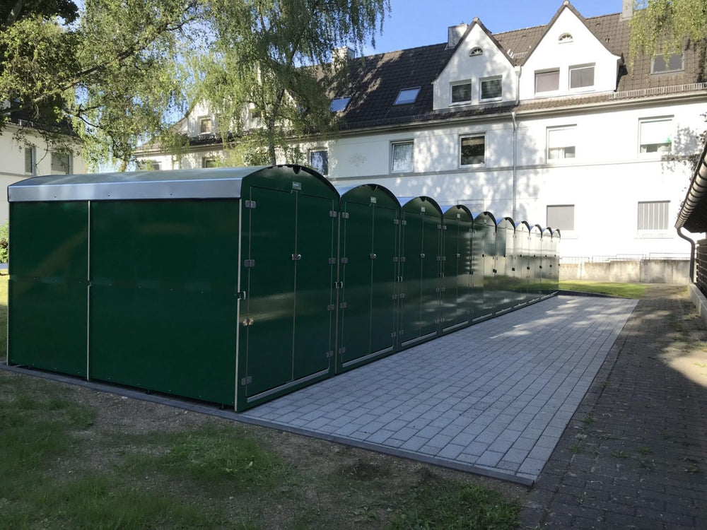 Reihe grüner Aufbewahrungsboxen für Kinderwagen und Fahrräder im Außenbereich