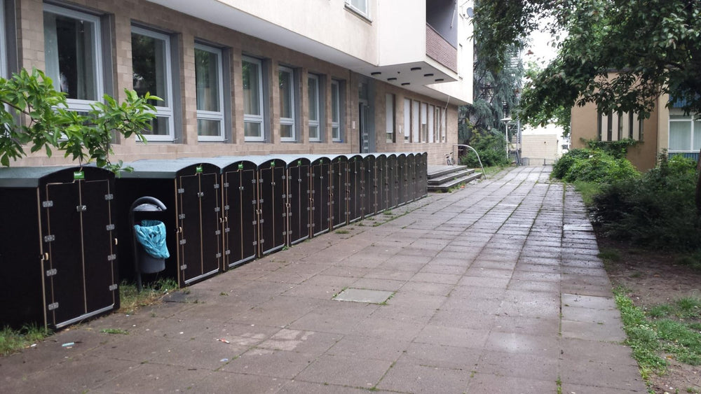Reihe diebstahlsichere Aufbewahrungsboxen für Kinderwagen und Fahrräder vor Gebäude