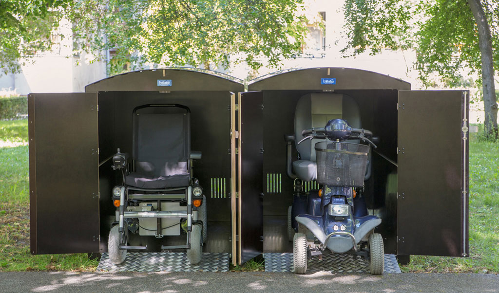 Elektromobile sicher geparkt in schwarzen Rollabo XXL Garagen im Grünen bei Sonnenschein