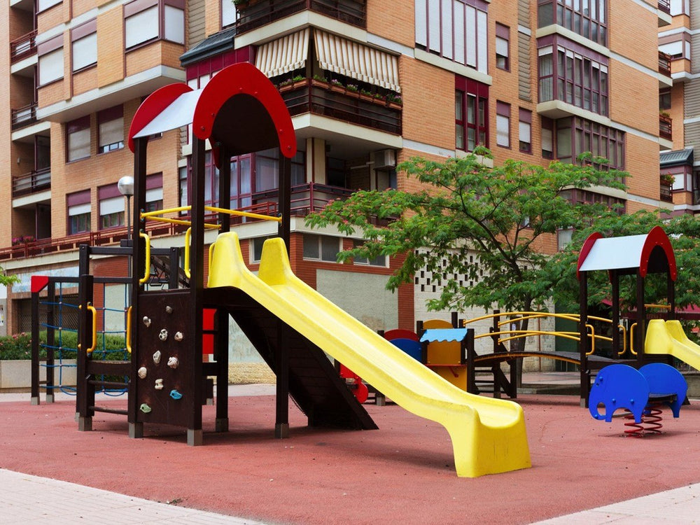 Spielplatz vor Wohnhäusern – Außenbereich einer kommunalen Kita