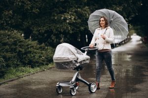 Mutter mit Regenschutz für Kinderwagen